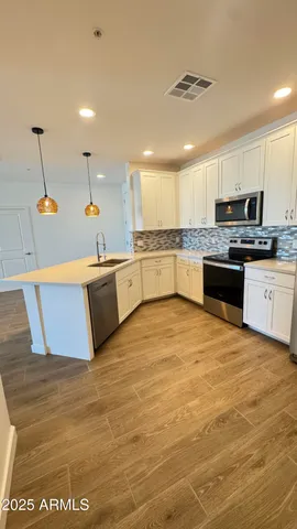 a large kitchen with stainless steel appliances granite countertop a sink and stove
