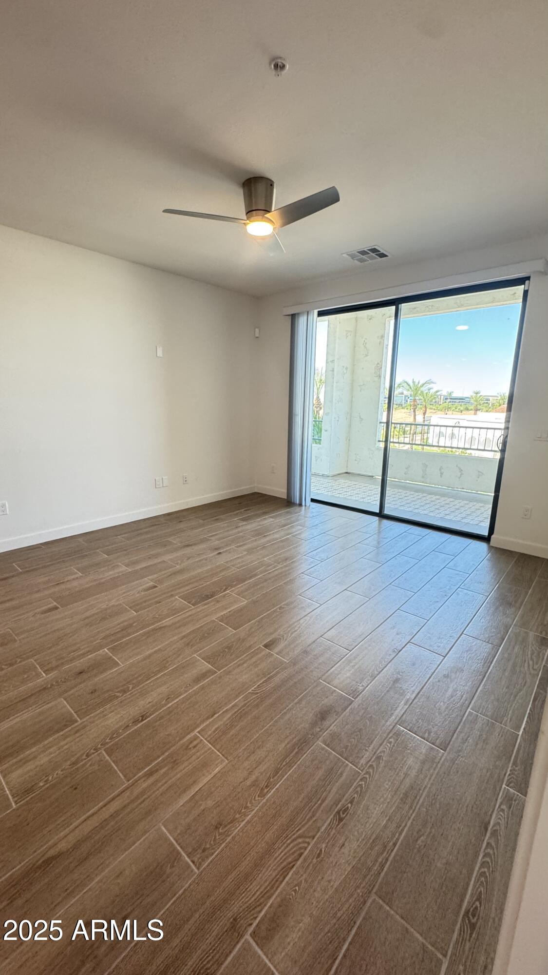2511 West Queen Creek Road, Unit 377 Chandler, AZ 85248 - Photo 12 of 47 an empty room with wooden floor and windows
