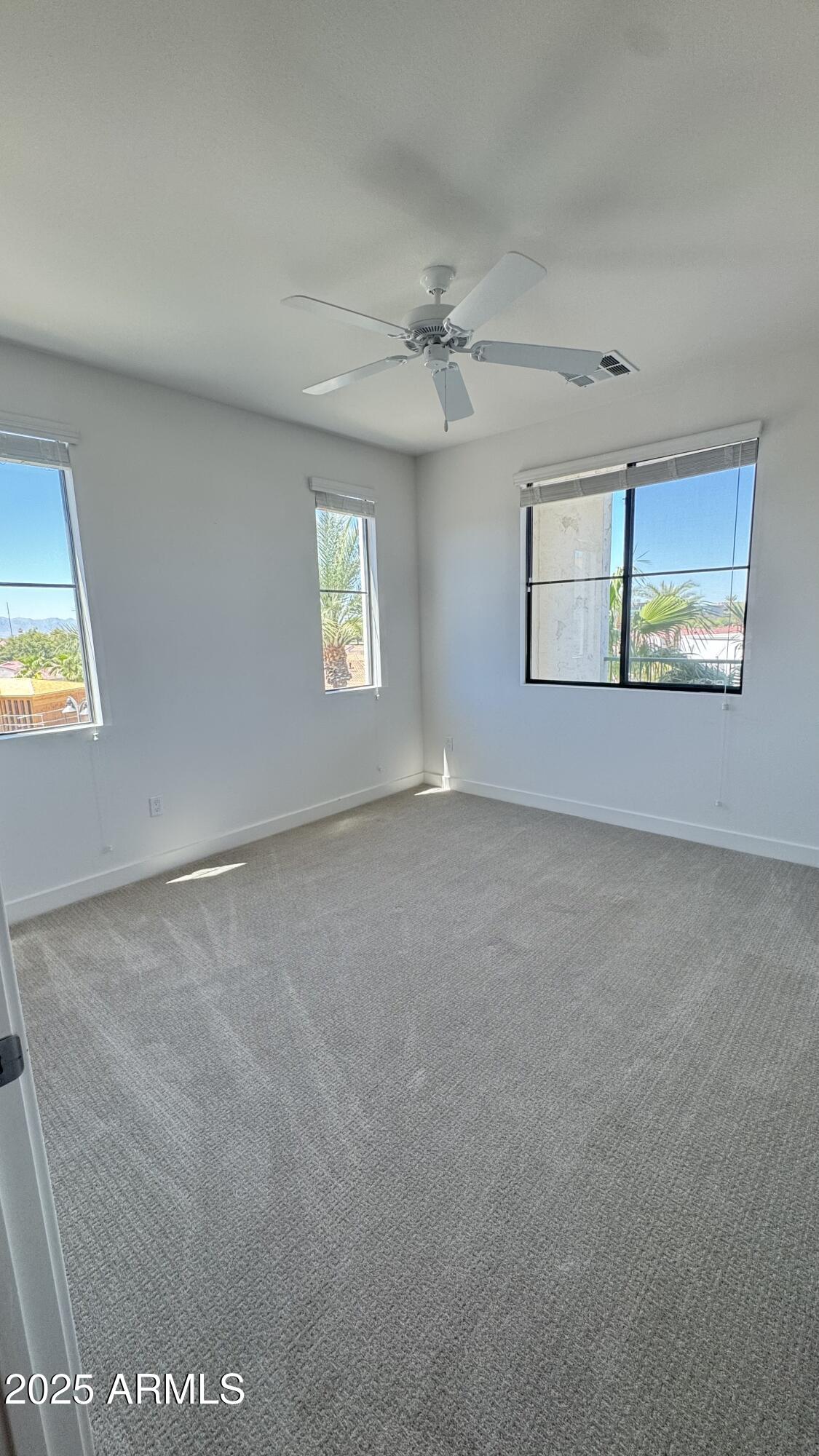 2511 West Queen Creek Road, Unit 377 Chandler, AZ 85248 - Photo 20 of 47 an empty room with windows and ceiling fan