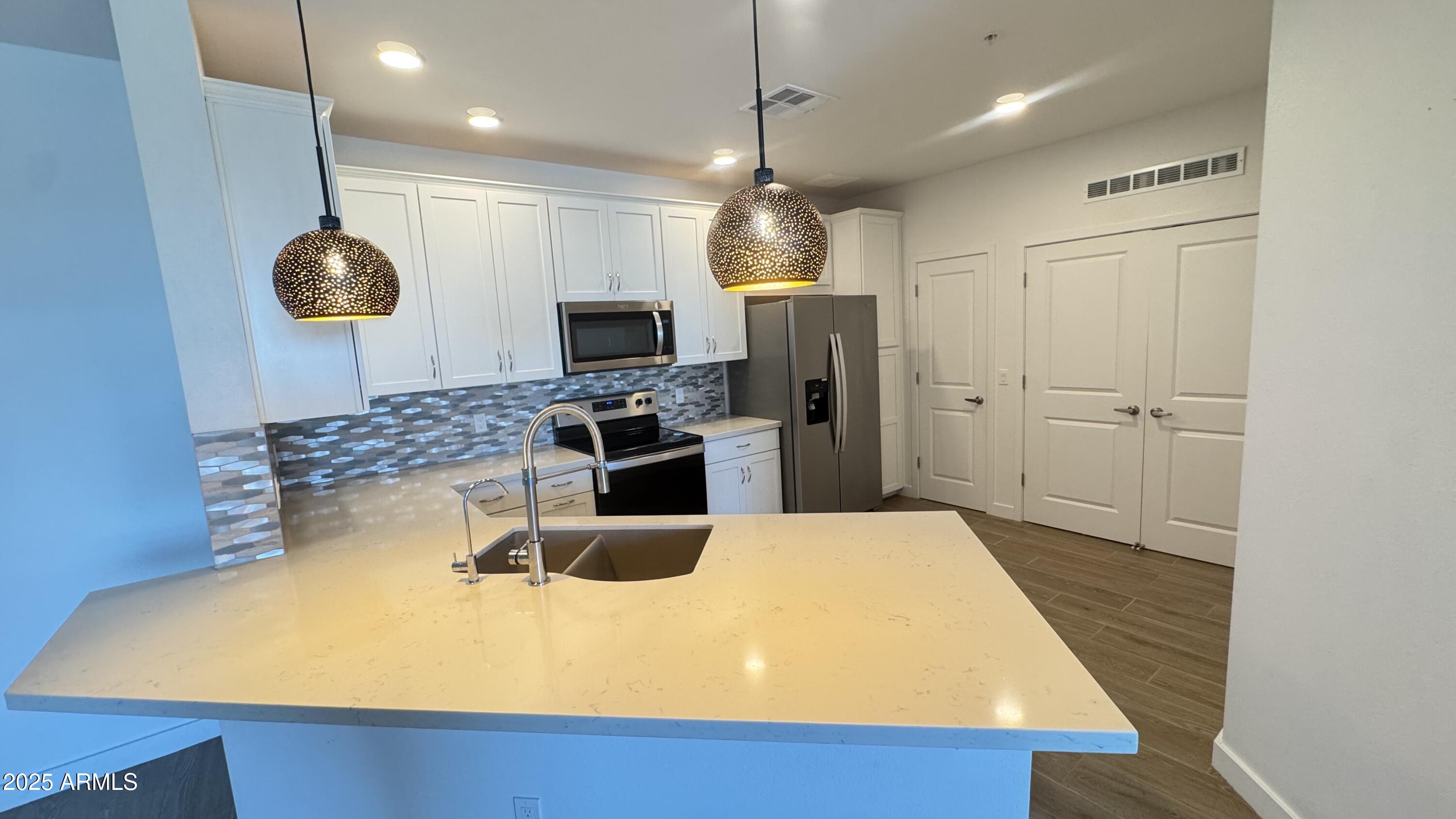 2511 West Queen Creek Road, Unit 377 Chandler, AZ 85248 - Photo 2 of 47 a kitchen with a refrigerator a stove and a sink