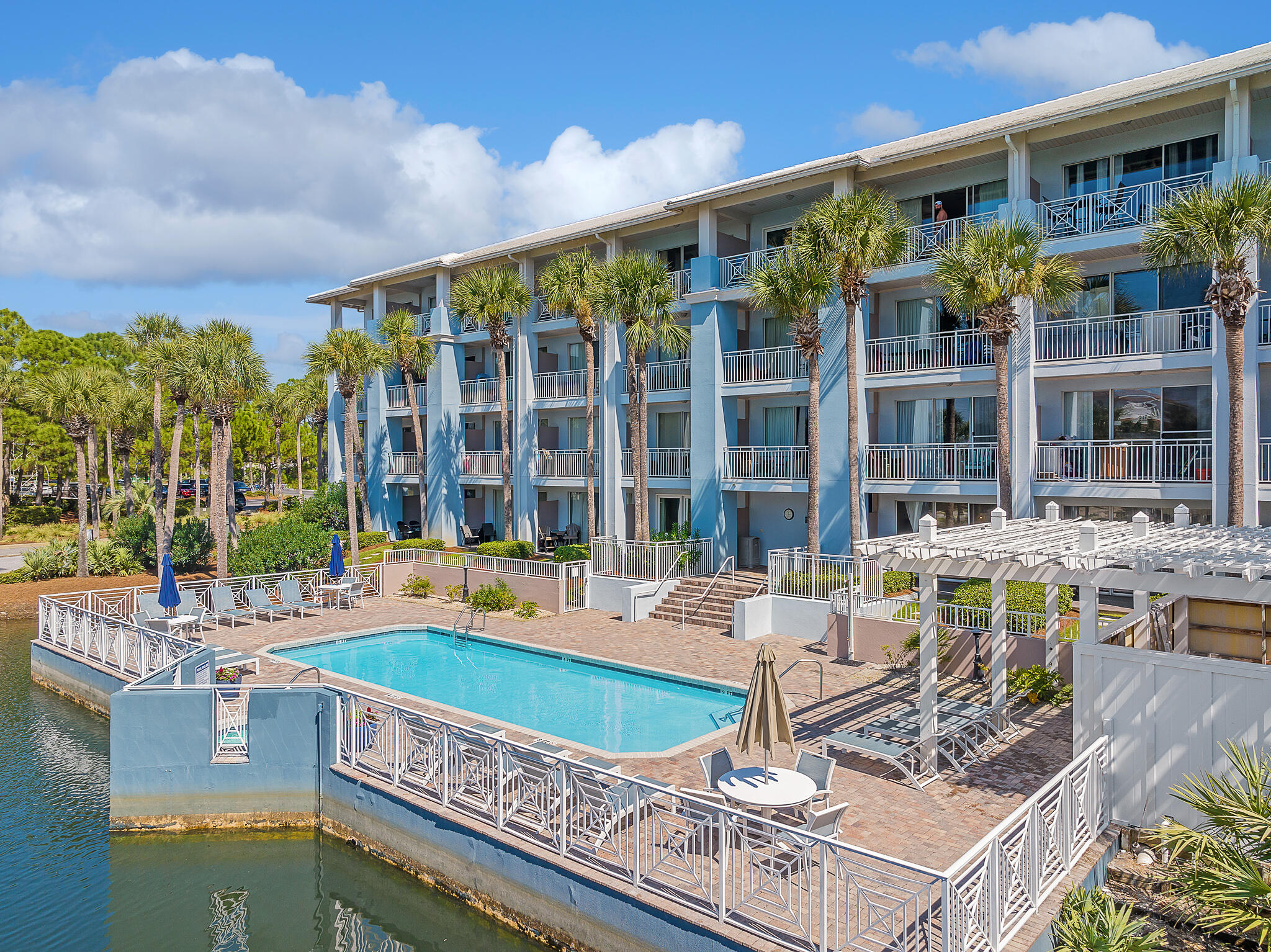145 Spires Lane, Unit 411 Santa Rosa Beach, FL 32459 - Photo 37 of 44 a large white building with a swimming pool and glass windows