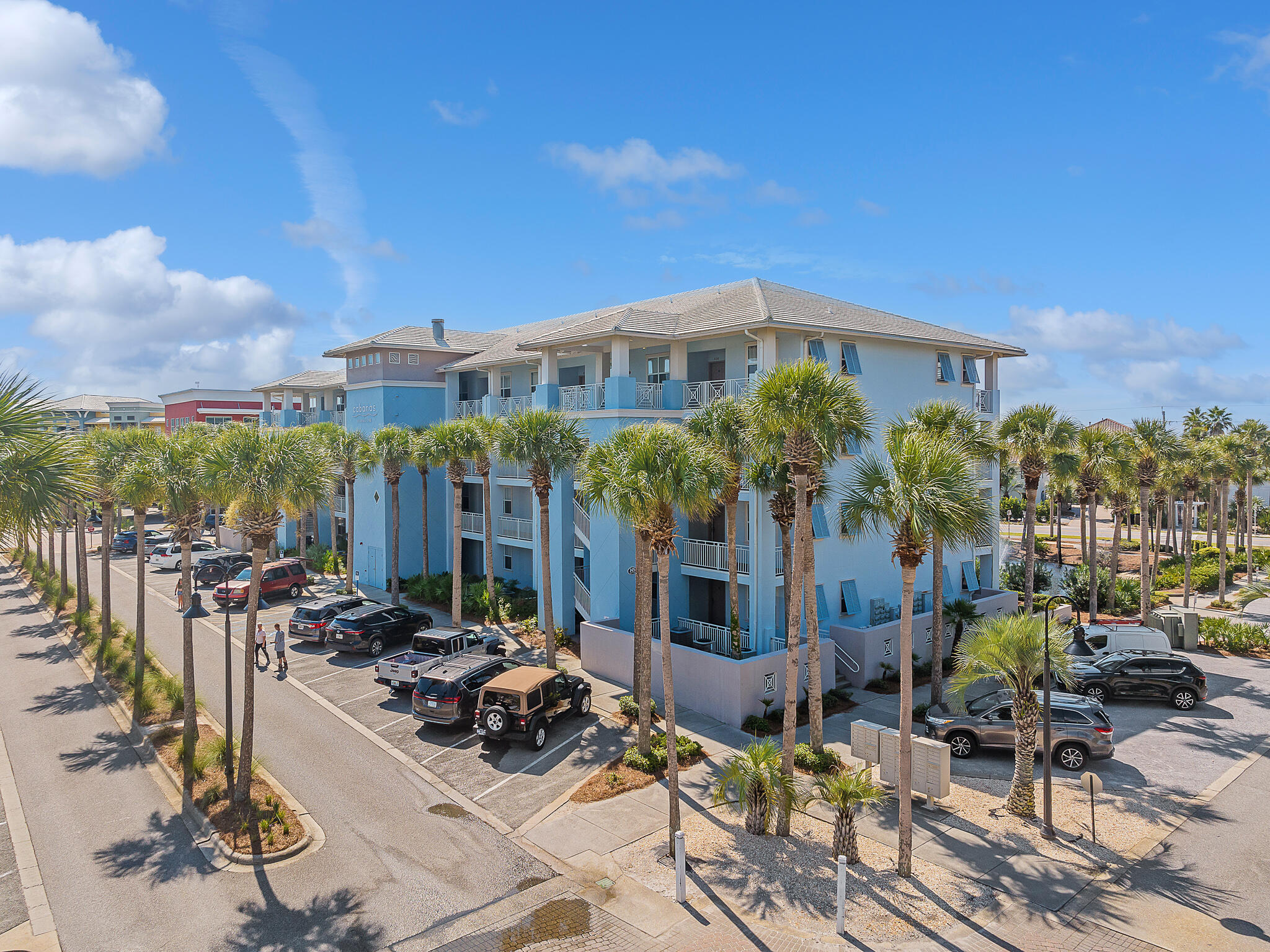 145 Spires Lane, Unit 411 Santa Rosa Beach, FL 32459 - Photo 42 of 44 a view of a patio with couches table and chairs under an umbrella with large trees