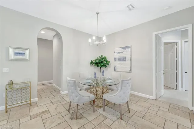 a dining room with chandelier and window
