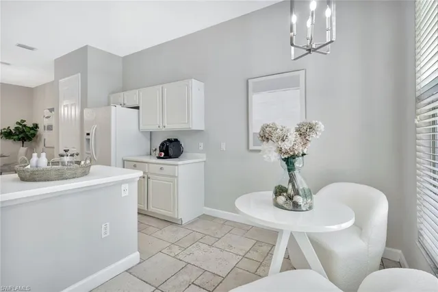 a dining room with wooden floor a chandelier a wooden table and chairs