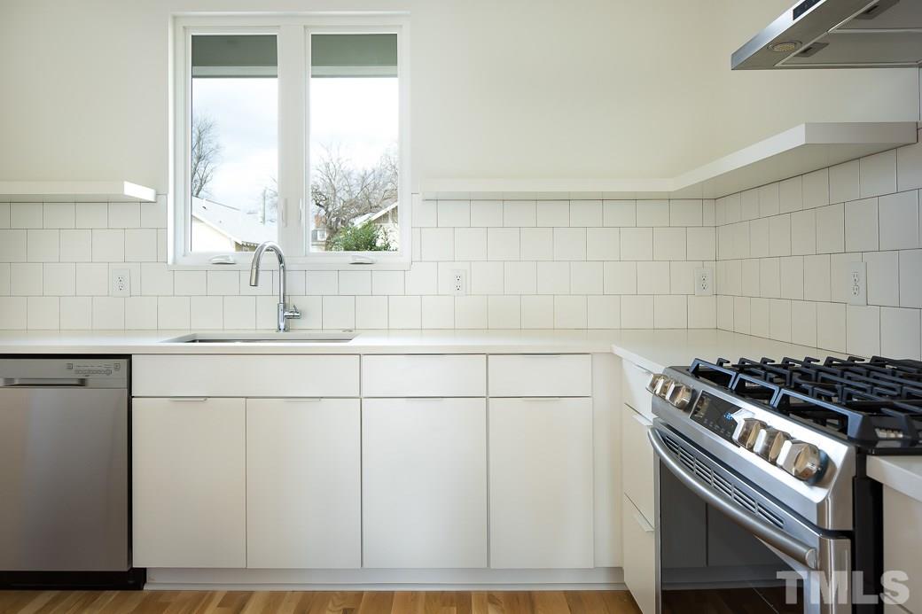 617 New Bern Avenue Raleigh, NC 27601 - Photo 5 of 16 a view of a kitchen counter space a stove and a sink