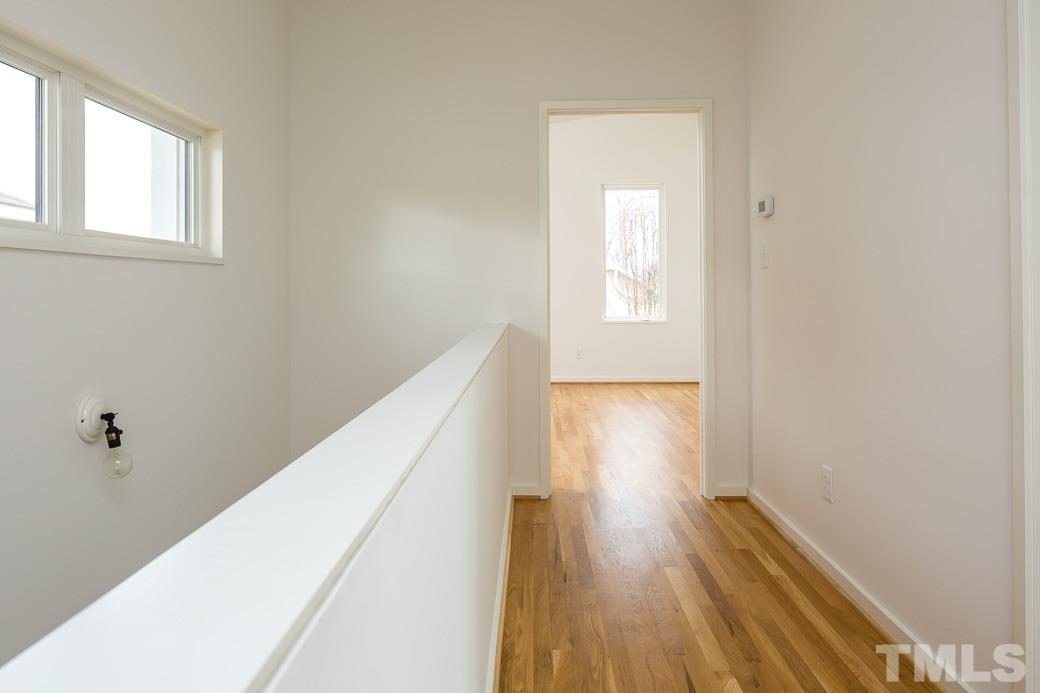 617 New Bern Avenue Raleigh, NC 27601 - Photo 9 of 16 a view of a hallway with wooden floor and a bathroom