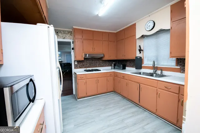 a kitchen with granite countertop a sink a counter space and cabinets