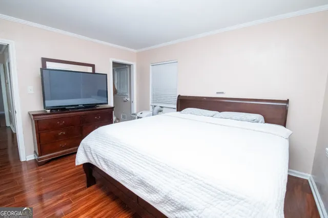 a bedroom with a bed and a flat screen tv