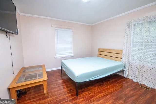 a bedroom with a bed and wooden floor