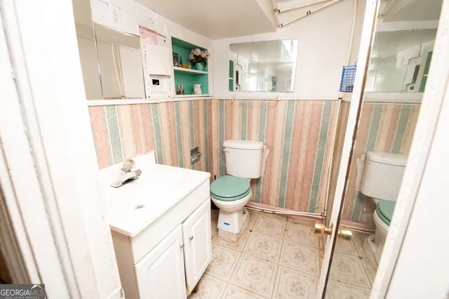 a bathroom with a sink a toilet and a mirror