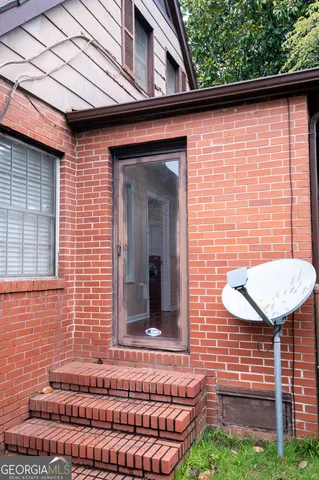 a view of a brick house with a small backyard