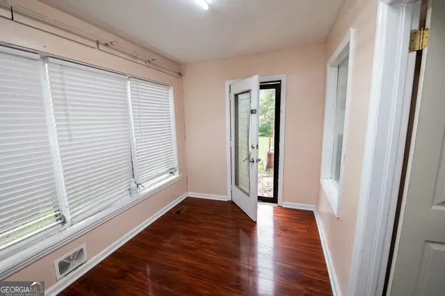 a view of a hallway with wooden floor and a window