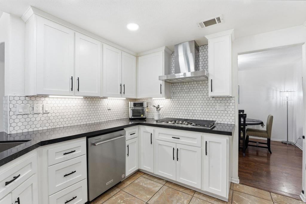 2505 Whispering Palms Loop Chula Vista, CA 91915 - Photo 11 of 45 a kitchen with granite countertop white cabinets and white appliances