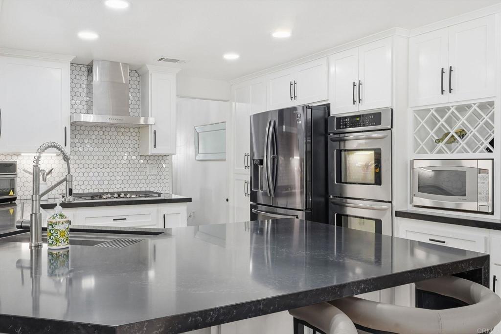 2505 Whispering Palms Loop Chula Vista, CA 91915 - Photo 12 of 45 a kitchen with stainless steel appliances granite countertop a sink a stove and a microwave