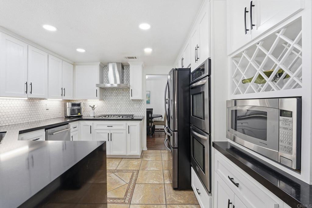 2505 Whispering Palms Loop Chula Vista, CA 91915 - Photo 13 of 45 a kitchen with granite countertop stainless steel appliances and wooden cabinets