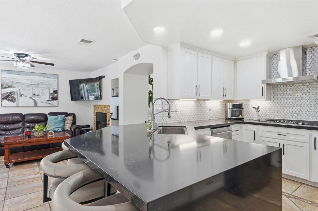 2505 Whispering Palms Loop Chula Vista, CA 91915 - Photo 14 of 45 a kitchen with kitchen island a stove a table and chairs in it