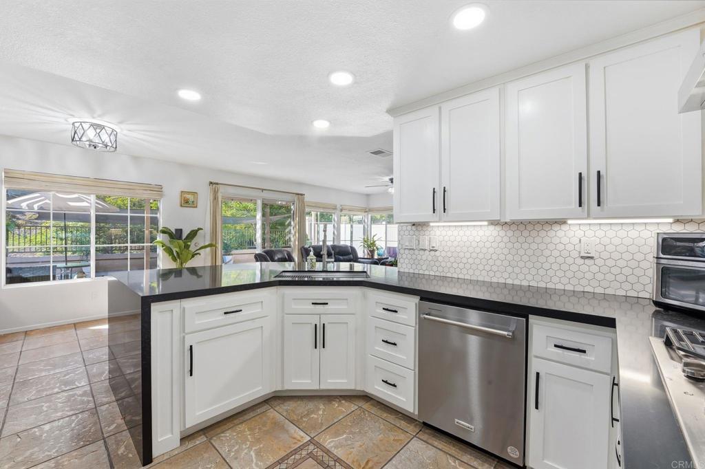 2505 Whispering Palms Loop Chula Vista, CA 91915 - Photo 9 of 45 a kitchen with granite countertop white cabinets and white appliances