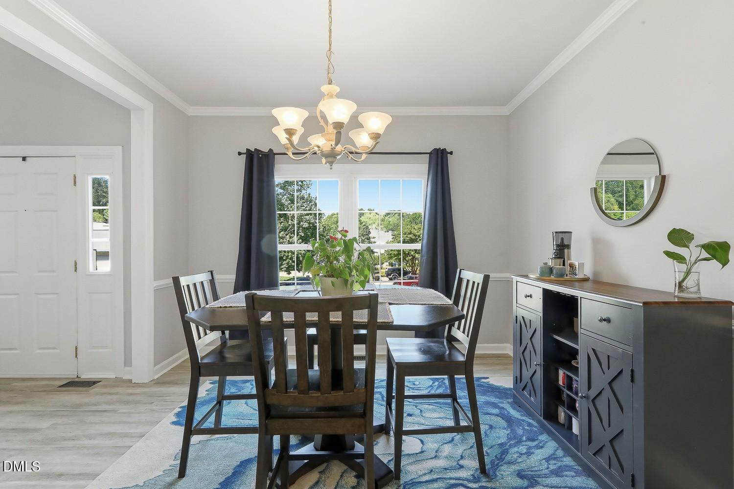 4001 Batiste Road Raleigh, NC 27613 - Photo 23 of 63 a view of a dining room with furniture a chandelier and wooden floor