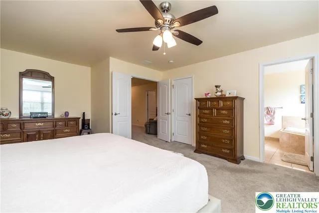 a spacious bedroom with a bed and a dresser