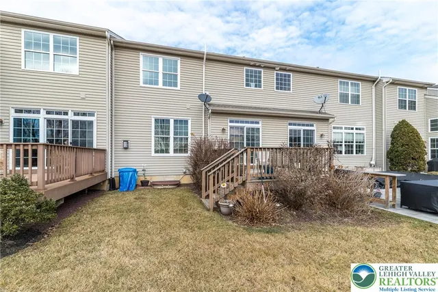a view of a house with backyard and sitting area