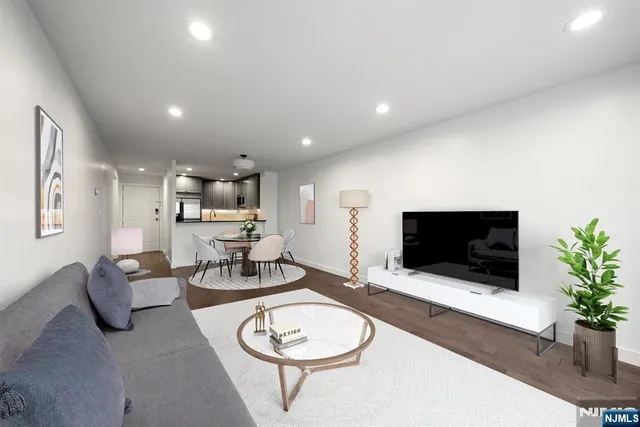 a living room with furniture a flat screen tv and a potted plant
