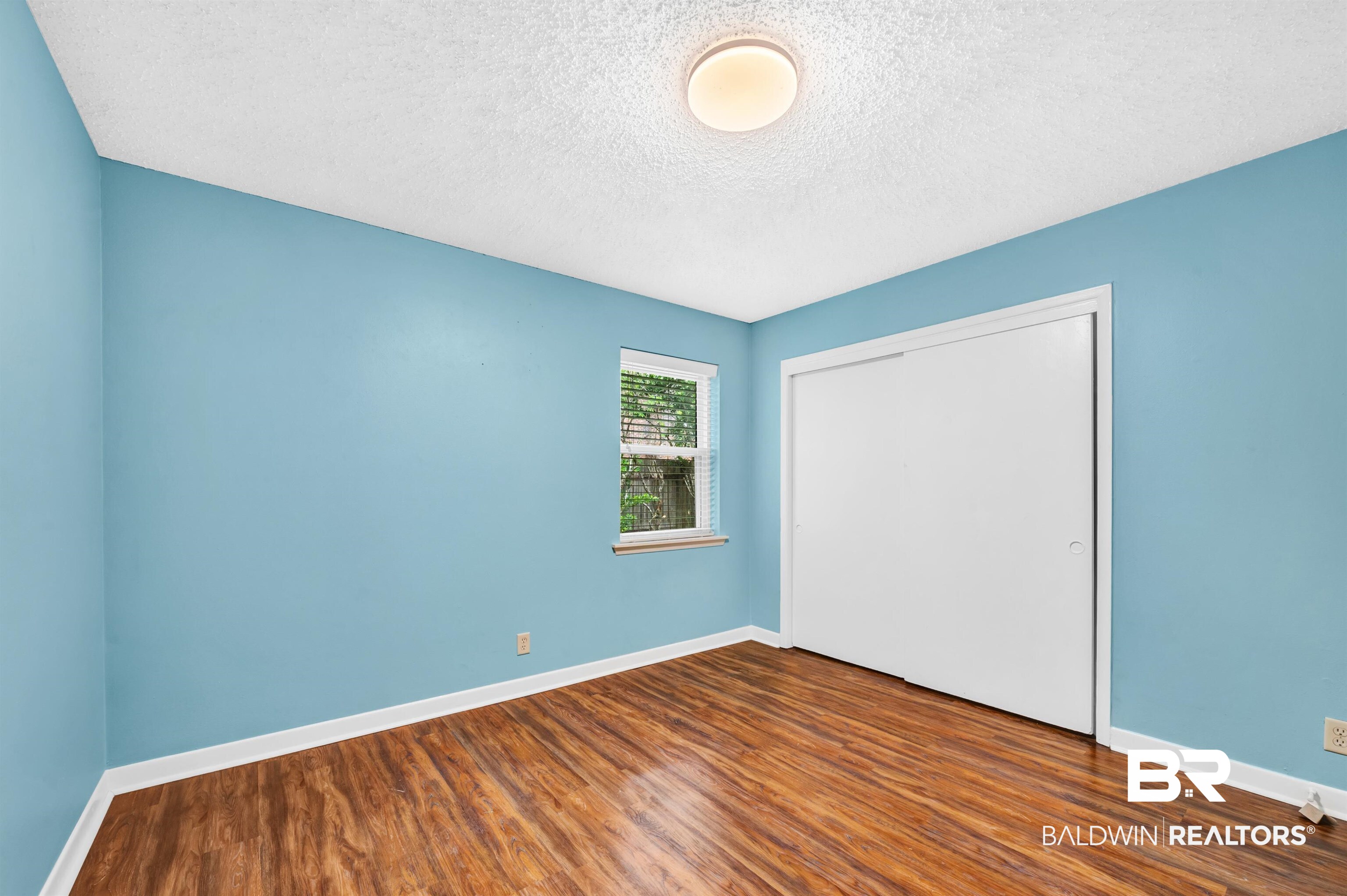 28 Caisson Trace Spanish Fort, AL 36527 - Photo 32 of 51 Unfurnished bedroom featuring a textured ceiling, wood finished floors, baseboards, and a closet