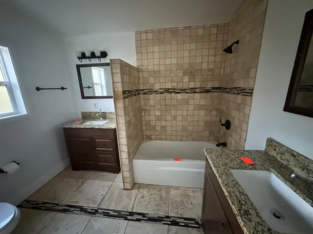 a bathroom with a tub sink toilet and shower