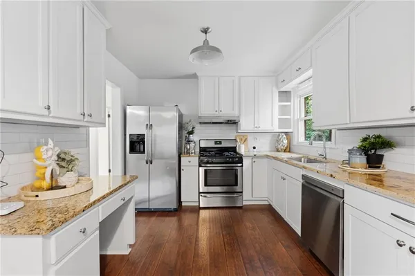 a kitchen with kitchen island granite countertop a sink a counter space and stainless steel appliances