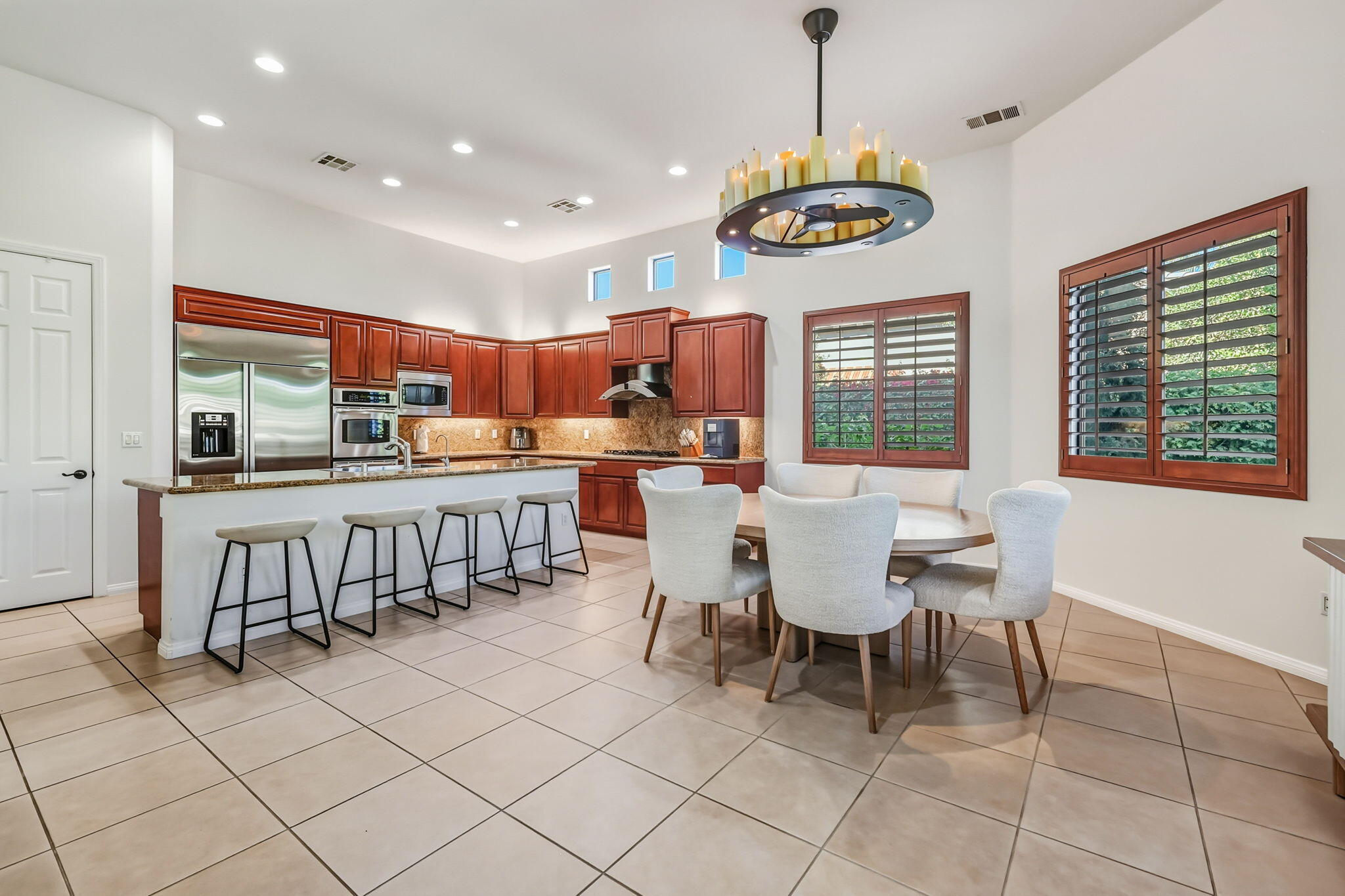 57914 Santa Rosa Trail La Quinta, CA 92253 - Photo 7 of 14 a dining room filled with stainless steel appliances kitchen island granite countertop a table chairs and a refrigerator