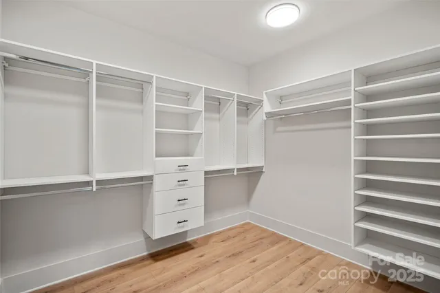 a view of walk in closet with empty racks