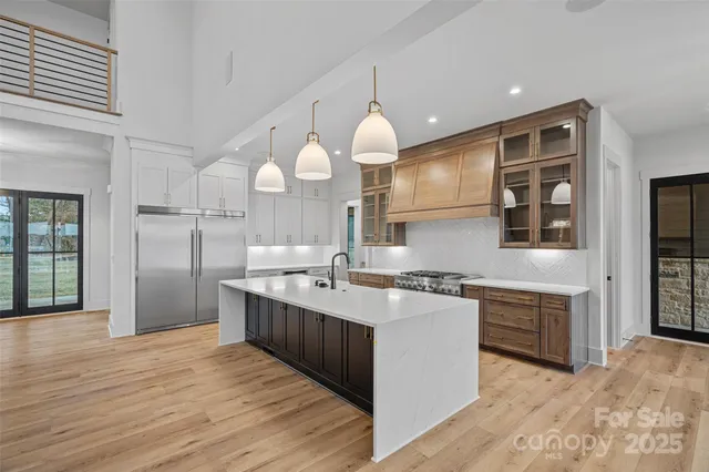 a kitchen with kitchen island granite countertop a sink cabinets and stainless steel appliances