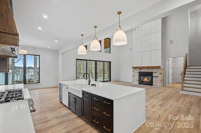 a large white kitchen with a sink and a fireplace