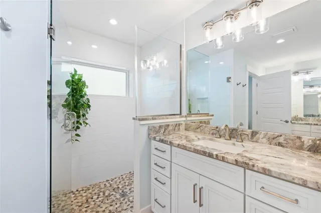 a bathroom with a granite countertop sink and a mirror