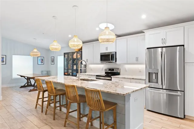 a large kitchen with stainless steel appliances granite countertop a lot of counter space and wooden floors