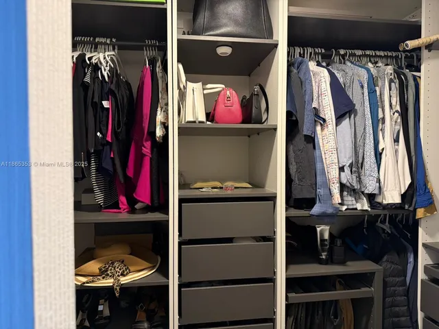 a view of walk in closet with clothes and shoes