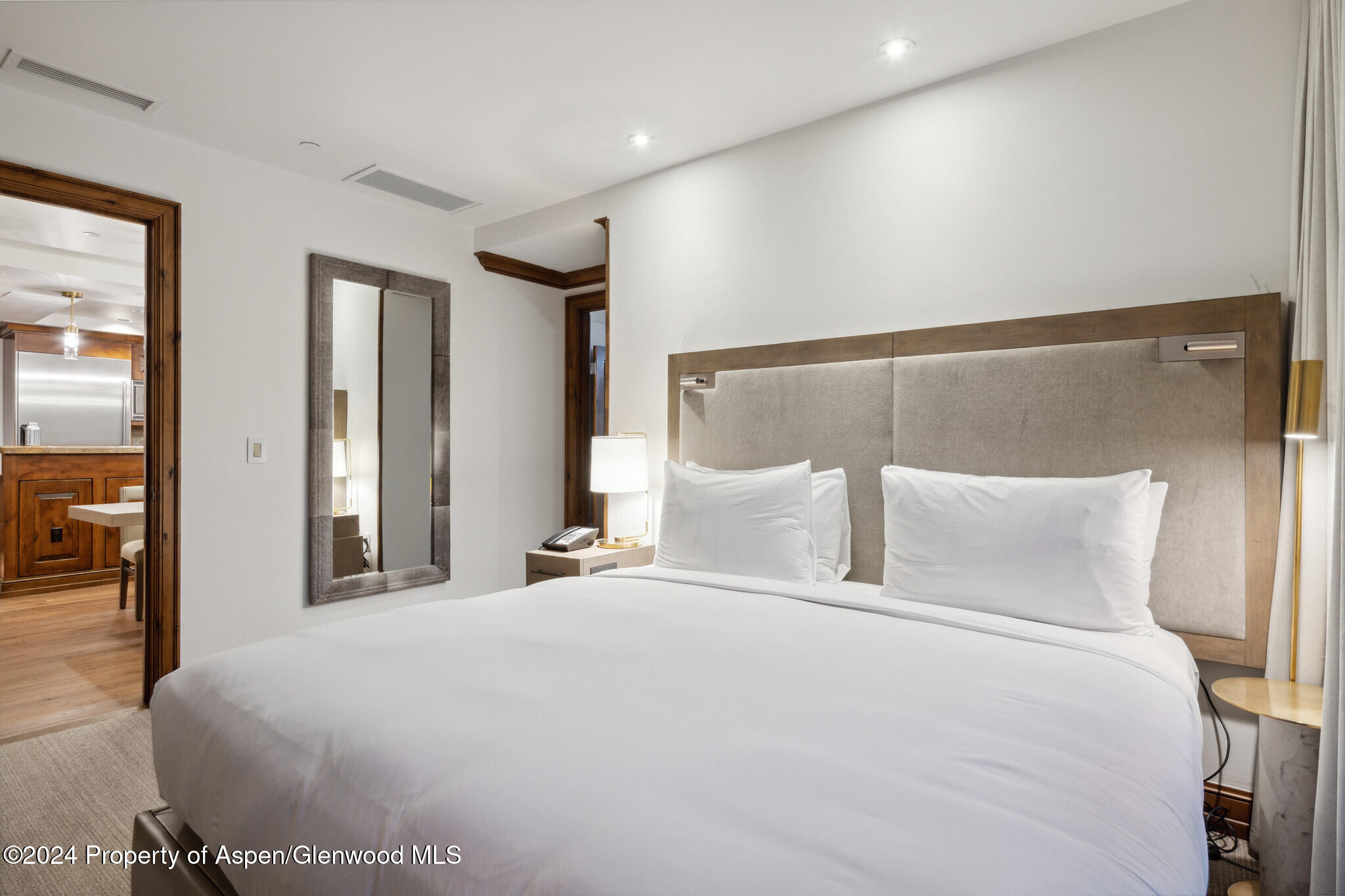 415 East Dean St Unit 46 Week 12 Aspen, CO 81611 - Photo 14 of 27 a large bed in a white room with a large mirror