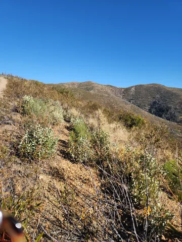 a view of a large mountain with mountains in the background