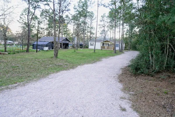 a view of a house with a big yard and large trees