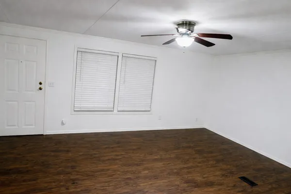 a view of an empty room with wooden floor