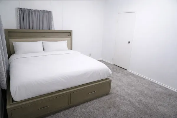 a bedroom with a bed and a potted plant