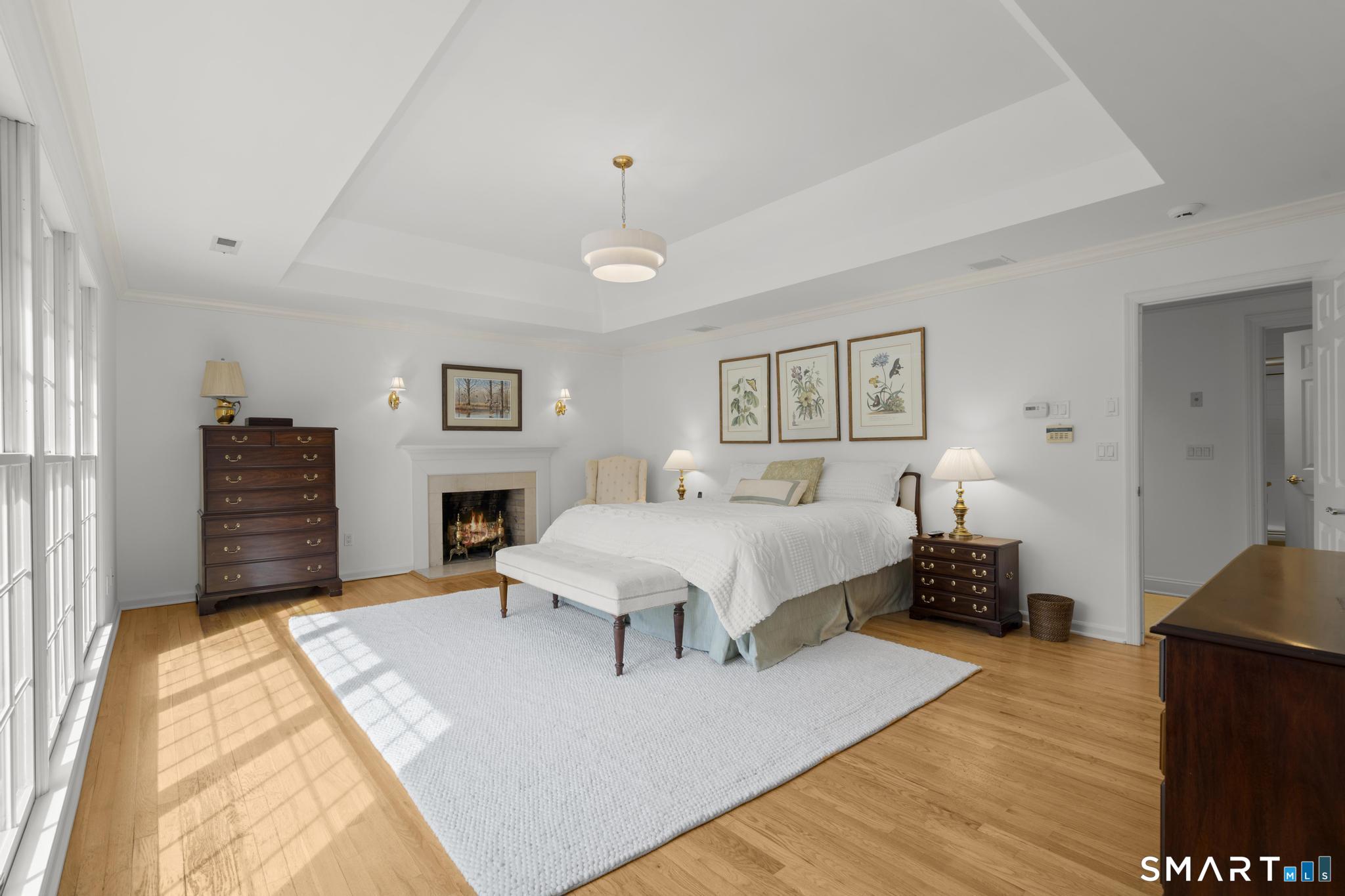 8 Maplewood Lane Wilton, CT 06897 - Photo 17 of 40 a spacious bedroom with a bed a dresser and painting on the wall