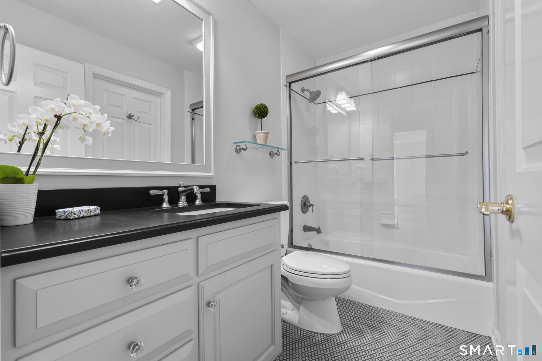 8 Maplewood Lane Wilton, CT 06897 - Photo 26 of 40 a bathroom with a granite countertop sink a toilet a mirror and shower