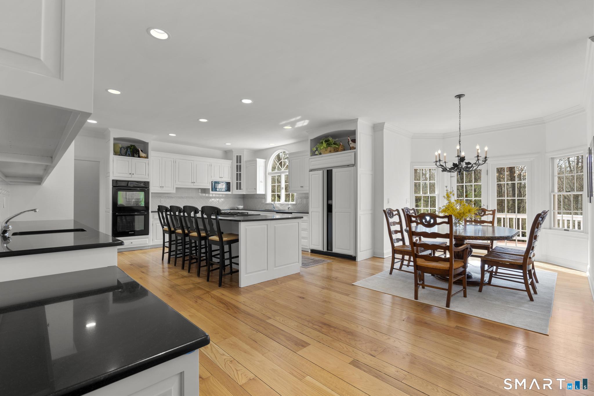 8 Maplewood Lane Wilton, CT 06897 - Photo 10 of 40 a kitchen with stainless steel appliances kitchen island granite countertop a table chairs and a refrigerator