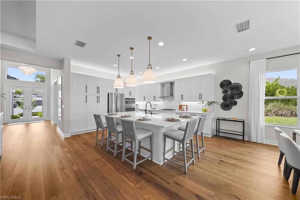 12092 Eucalyptus Way Naples, FL 34120 - Photo 12 of 50 a view of a dining room with furniture and wooden floor