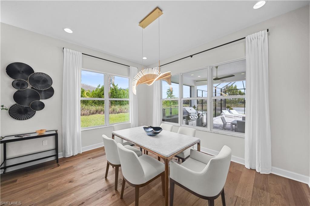 12092 Eucalyptus Way Naples, FL 34120 - Photo 14 of 50 a dining room with furniture a chandelier and wooden floor