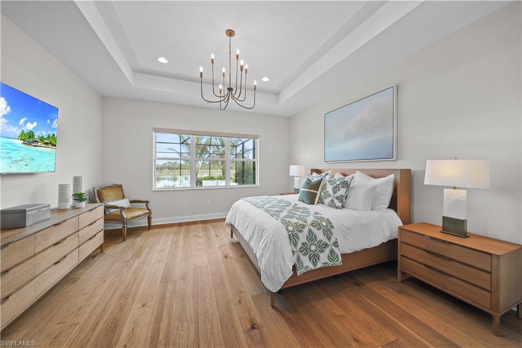 12092 Eucalyptus Way Naples, FL 34120 - Photo 16 of 50 a spacious bedroom with a bed and a chandelier
