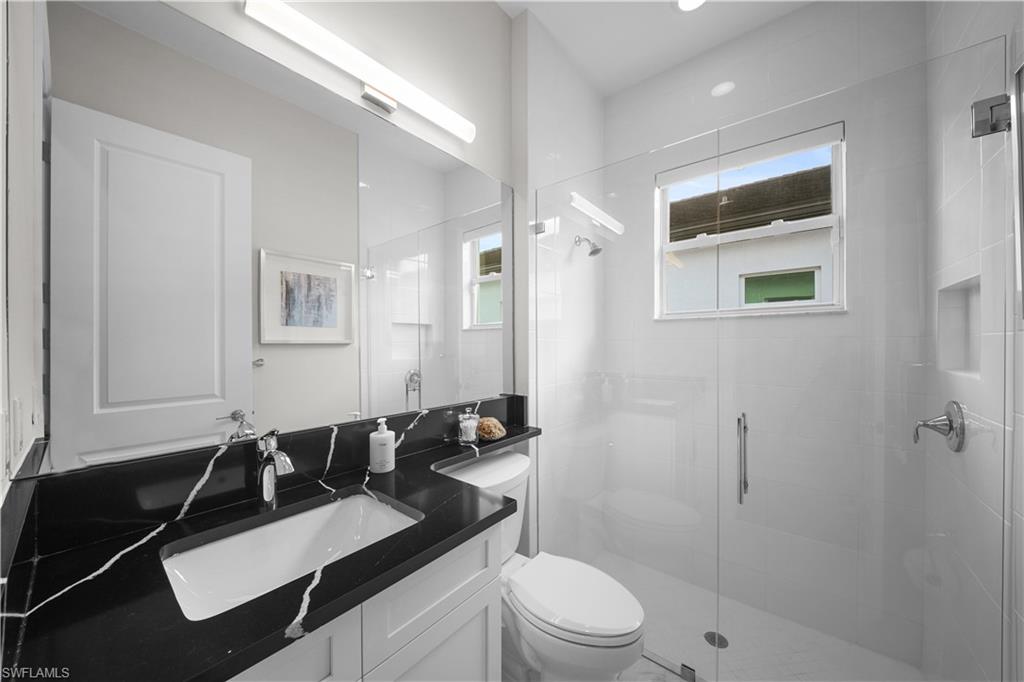 12092 Eucalyptus Way Naples, FL 34120 - Photo 23 of 50 a bathroom with a sink a toilet and shower