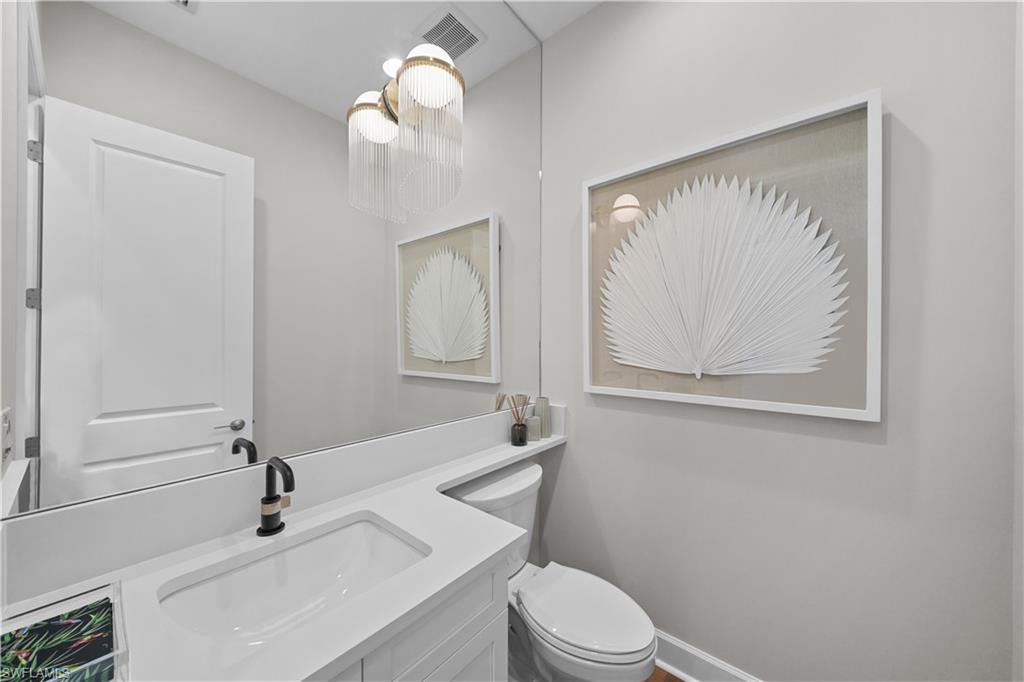 12092 Eucalyptus Way Naples, FL 34120 - Photo 24 of 50 a bathroom with a sink a toilet and mirror