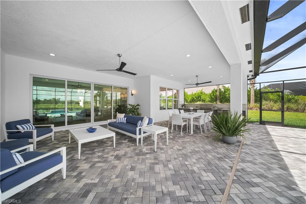 12092 Eucalyptus Way Naples, FL 34120 - Photo 27 of 50 a living room with patio furniture and floor to ceiling windows