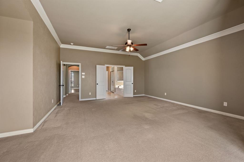 282 Heather Lane Decatur, TX 76234 - Photo 15 of 35 an empty room with chandelier fan and windows